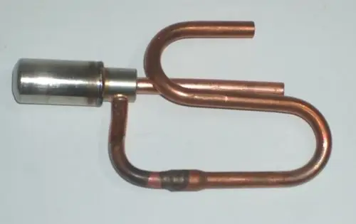 Daikin Ventilantrieb mit einer Kombination aus metallischen und kupfernen Komponenten, in einer gebogenen Form, auf einem neutralen Hintergrund.